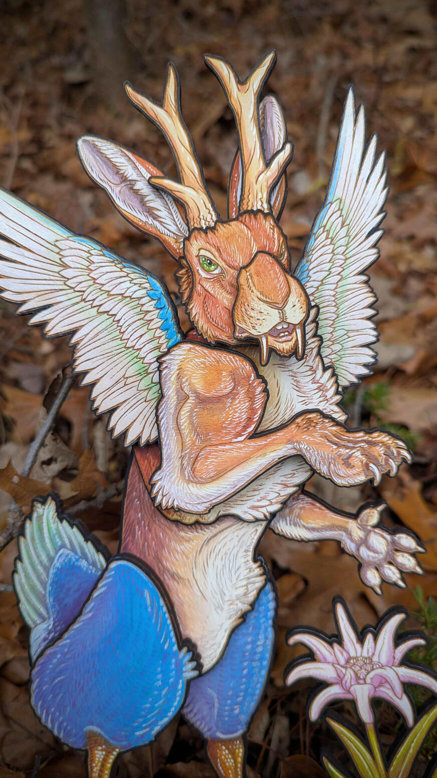 wood and watercolor rabbit with fangs, antlers, duck feet and wings.